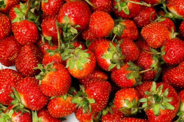 Massor av jordgubbar arrangerade som bakgrund — Stockfoto