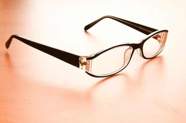 Brýle na čtení na dřevěný stůl — Stock fotografie
