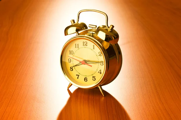 Alarm clock against wooden background — Stock Photo, Image