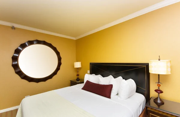 Cama doble en la habitación del hotel — Foto de Stock