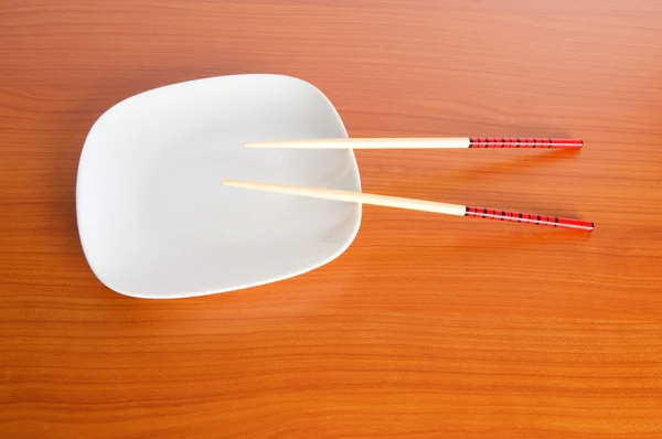 Plate with chopsticks on the wooden table — Stock Photo, Image