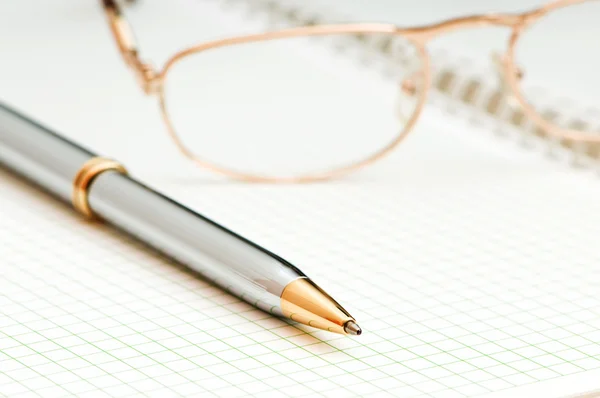 Stift und Brille auf der Seite — Stockfoto