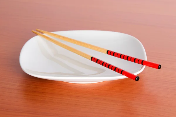 Plate with chopsticks on the wooden table — Stock Photo, Image