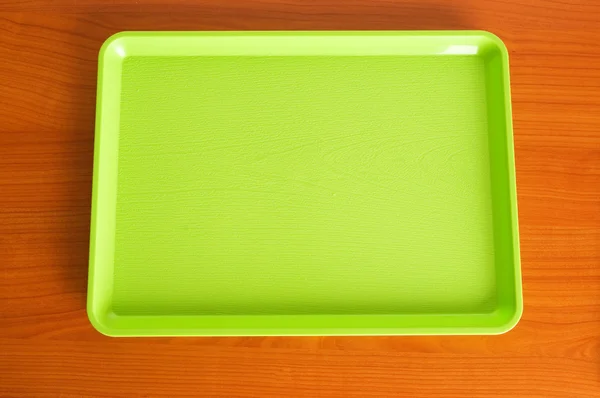 Vihreä tarjotin puupöydällä — kuvapankkivalokuva