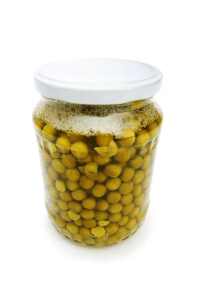 白で隔離されるガラス瓶の緑エンドウ豆 — ストック写真