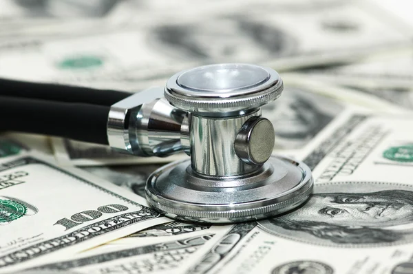 Estetoscópio e dólares ilustrando cuidados de saúde caros — Fotografia de Stock