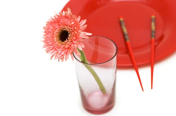 Red flower and plate with chopsticks isolated on white — Stock Photo, Image