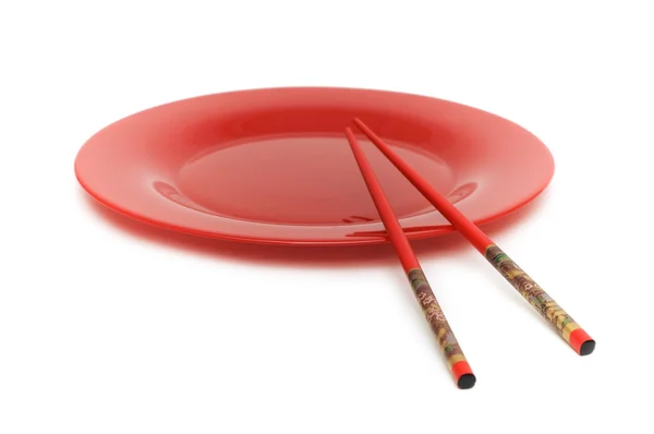 Червона тарілка і палички ізольовані на білому — стокове фото