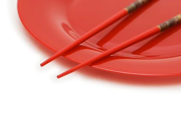 Red plate and chopsticks isolated on the white — Stock Photo, Image