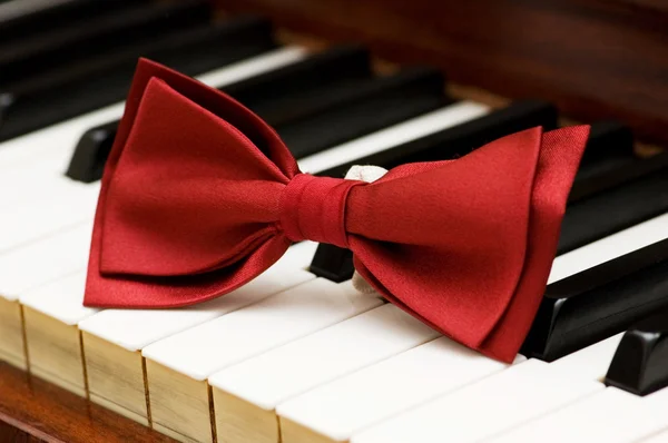 Red bow tie on the piano keys — Stock Photo, Image