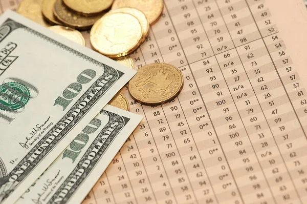 Munten en dollars over financiële getallen uit kranten — Stockfoto