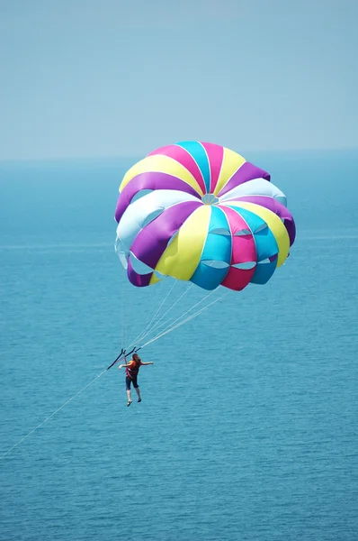 Multi coloured parachute over the blue sky — Stock Photo, Image