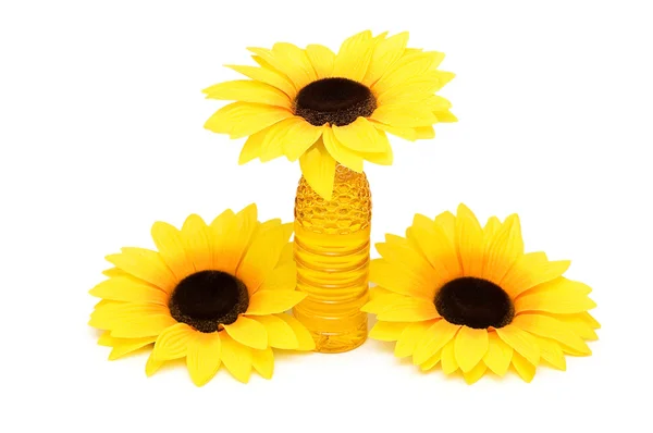 Three sunflowers and bottle of oil isolated on white — Stock Photo, Image
