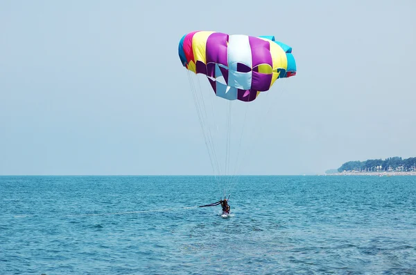 Meerkleurige parachute boven de blauwe lucht — Stockfoto