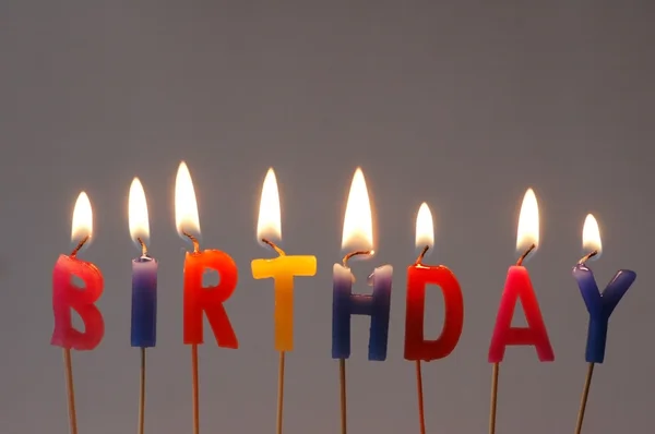 Hořící svíčky s obsahuje slovo "narozeniny" — Stock fotografie