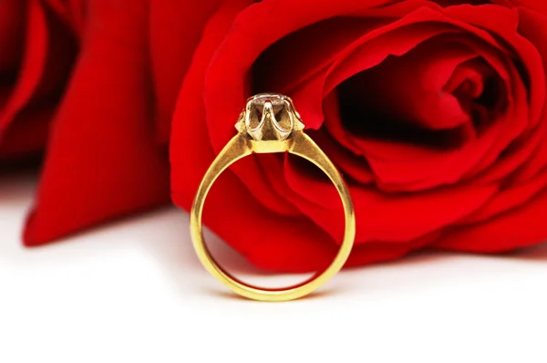 Diamantový prsten proti kytice rudých růží — Stock fotografie