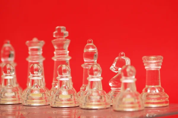 Verschiedene Schachfiguren vor rotem Hintergrund — Stockfoto