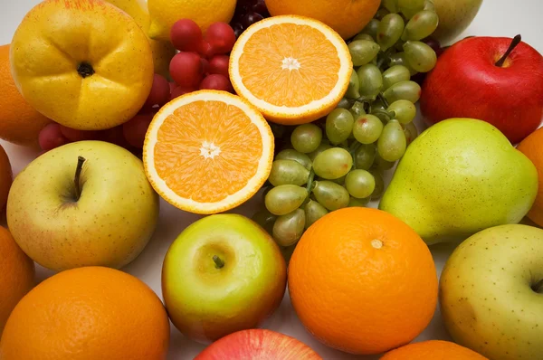Różne owoce - jabłka, gruszki, winogrona, pomarańcze — Zdjęcie stockowe