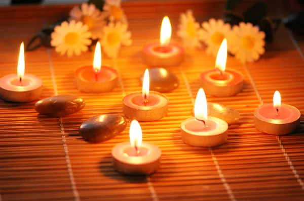 Ljus, blommor och stenar för aromterapi behandling — Stockfoto