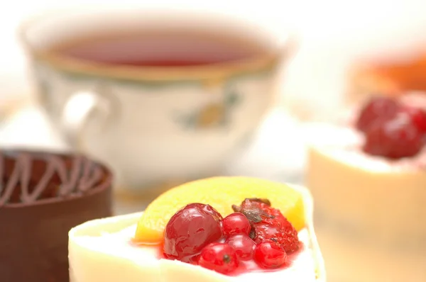 Sladký dort s ovocem a šálek čaje — Stock fotografie