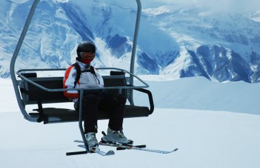 Skier on chair lift at ski resort clipart