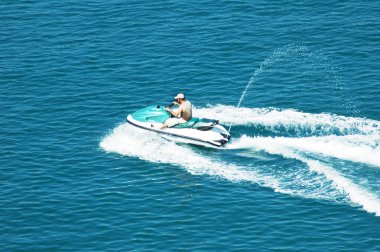 Man driving a motorised scooter at sea clipart