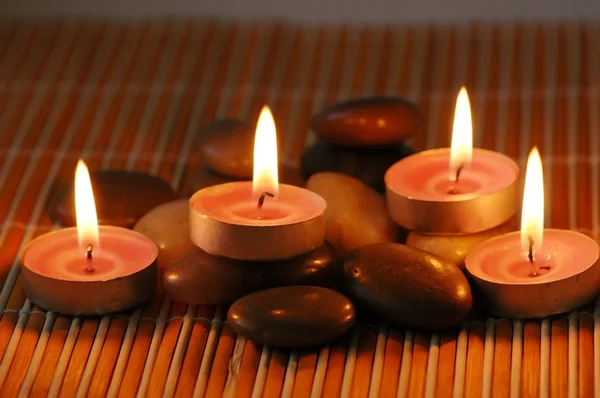 Kaarsen op de kiezelstenen voor aromatherapie sessie — Stockfoto