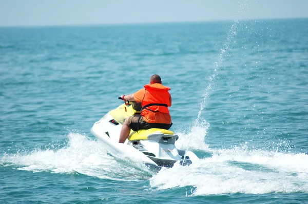 Man driving a motorised scooter at sea — Stock Photo, Image