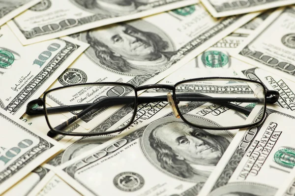 Reading glasses over the dollar bank notes — Stock Photo, Image