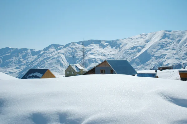 Höga berg och hus under snön i vinter — Stockfoto