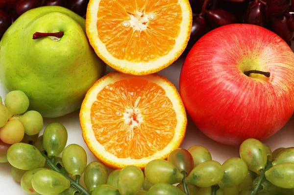 De helft gesneden sinaasappel en andere kleurrijke vruchten — Stockfoto