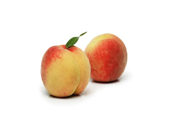 Twee perziken geïsoleerd op de witte achtergrond — Stockfoto