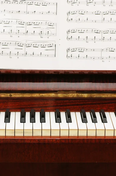 Piano met zwart-wit sleutels en muzieknoten — Stockfoto