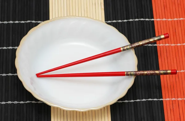 Λευκή πινακίδα και chopsticks σε ξύλινα χαλί — Φωτογραφία Αρχείου