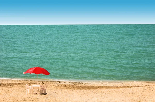 Mesa, sillas y sombrilla en la playa — Foto de Stock