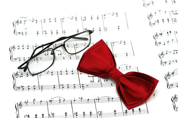 Bow tie and reading glasses on note paper — Stock Photo, Image