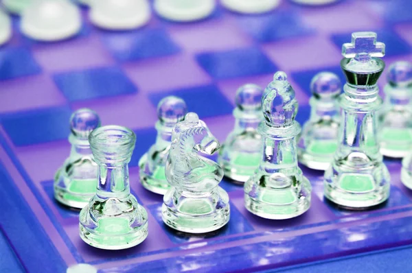 Varias figuras de ajedrez en el tablero de ajedrez de vidrio —  Fotos de Stock