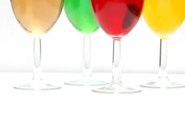 Γυαλιά με ποτά διαφόρων χρωμάτων σε λευκό — Φωτογραφία Αρχείου