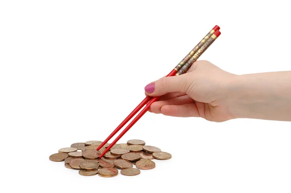 stock image Hand with red chopsticks eating golden coins