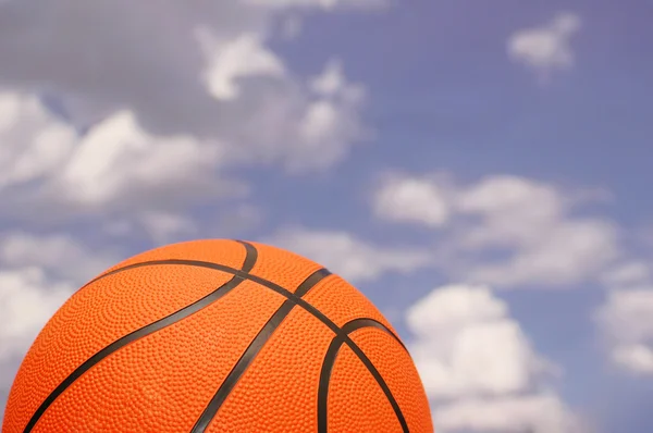 Oranžové Basketbal proti zamračená obloha — Stock fotografie