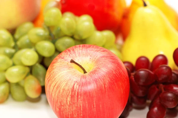 Червоне яблуко та інші фрукти на фоні — стокове фото