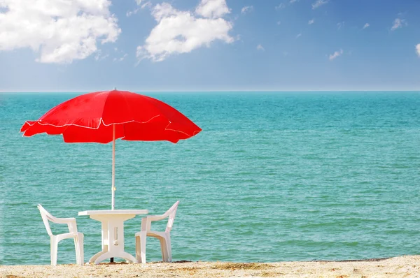 Table, chaises et parasol sur la plage — Photo