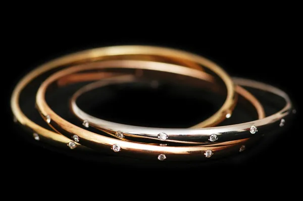 Three gold bracelets isolated on the white — Stock Photo, Image