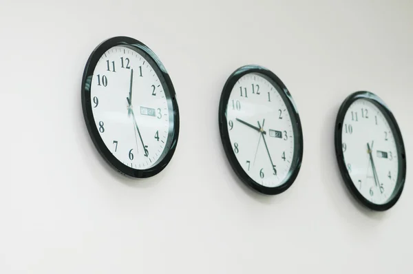 Row of round clocks on the wall — Stock Photo, Image
