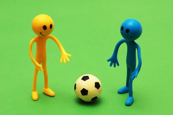 Two smilies playing football on green pitch — Stock Photo, Image