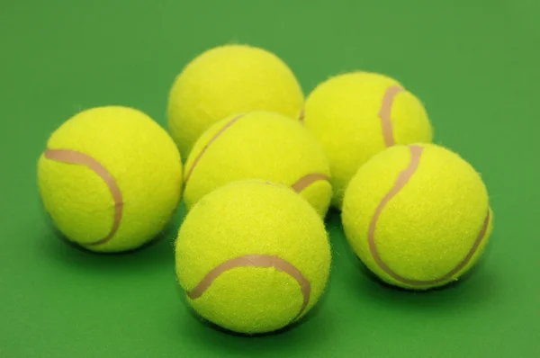 Šest tenisové míčky na zeleném pozadí — Stock fotografie