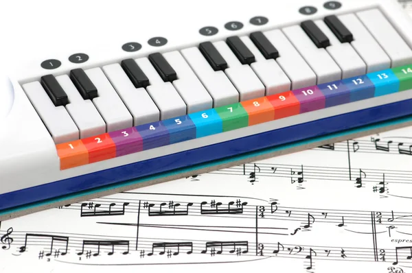 Notas e piano com teclas coloridas numeradas — Fotografia de Stock