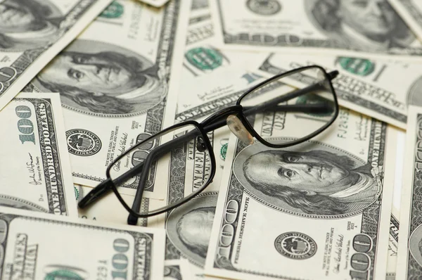 Čtení brýle přes sto dolaru bankovek — Stock fotografie