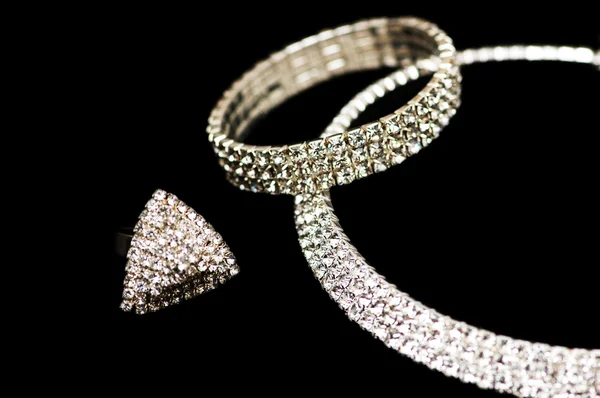 Кольцо, браслет и ожерелье изолированы на черном — стоковое фото