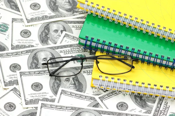 American dollars, reading glasses and notebooks — Stock Photo, Image